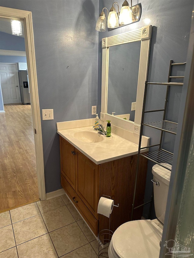 bathroom featuring tile patterned flooring, vanity, and toilet