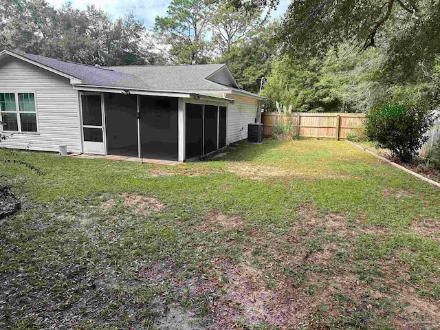 view of yard with a sunroom and central AC unit