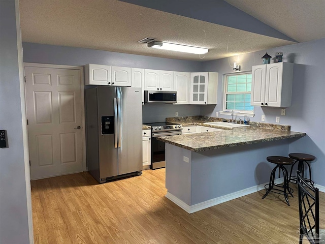 kitchen featuring white cabinets, sink, appliances with stainless steel finishes, and kitchen peninsula