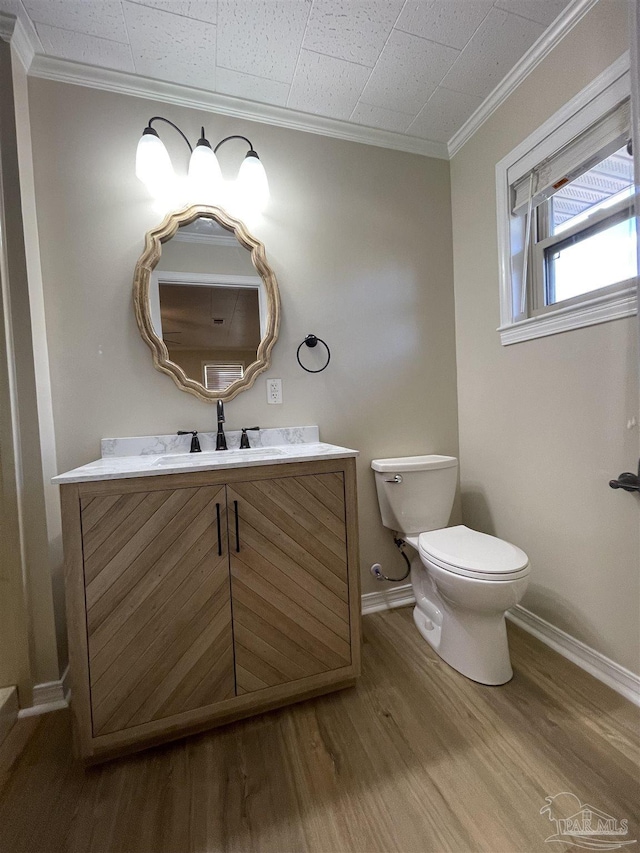 bathroom with vanity, wood-type flooring, ornamental molding, and toilet