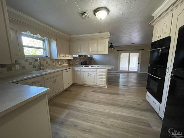 kitchen with sink, tasteful backsplash, light wood-type flooring, kitchen peninsula, and dishwasher