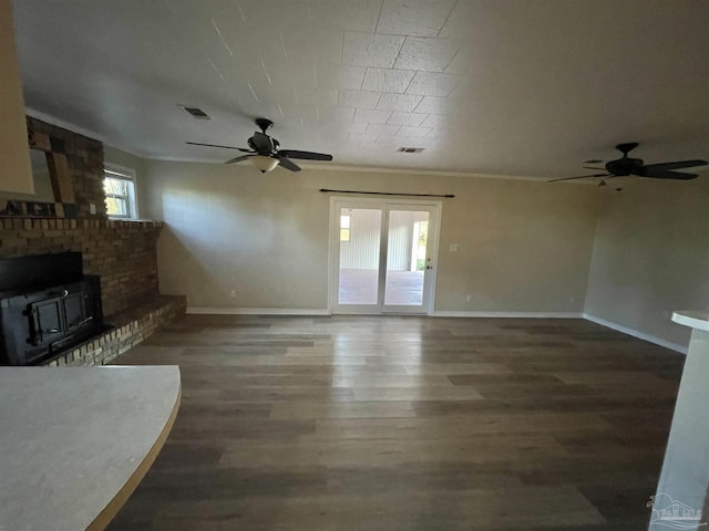 unfurnished living room with dark hardwood / wood-style flooring, ceiling fan, and a healthy amount of sunlight