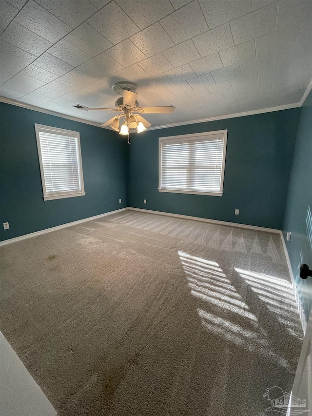 carpeted spare room featuring crown molding and ceiling fan