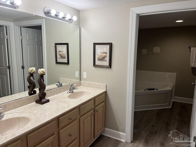 154 Ethel Wingate Dr Unit 210, Pensacola, FL 32507 - full bathroom featuring wood finished floors, double vanity, baseboards, and a bath