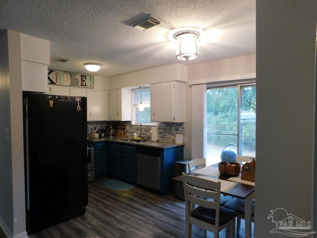 kitchen with appliances with stainless steel finishes, backsplash, white cabinetry, and plenty of natural light