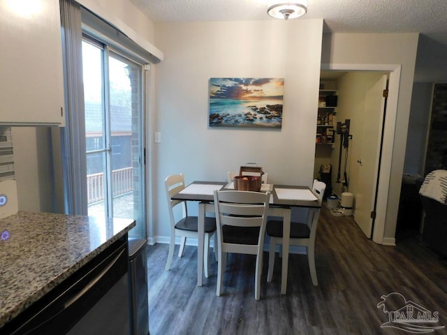 dining space with a textured ceiling and dark hardwood / wood-style flooring