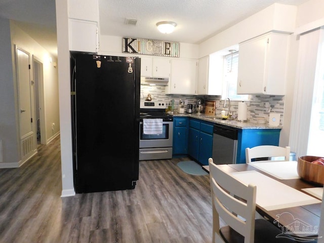 kitchen with white cabinets, decorative backsplash, stainless steel appliances, and blue cabinets