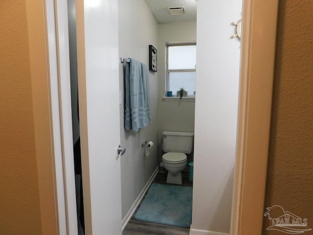 bathroom featuring hardwood / wood-style flooring and toilet