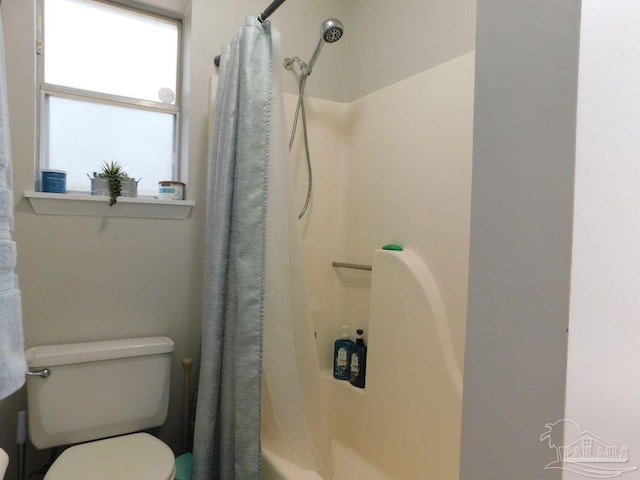 bathroom with shower / tub combo with curtain and toilet