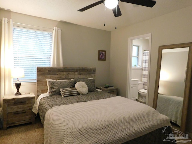 bedroom with ensuite bathroom, ceiling fan, and carpet floors