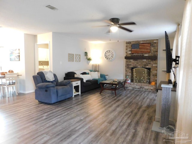 living room with ceiling fan, a fireplace, and dark wood-type flooring