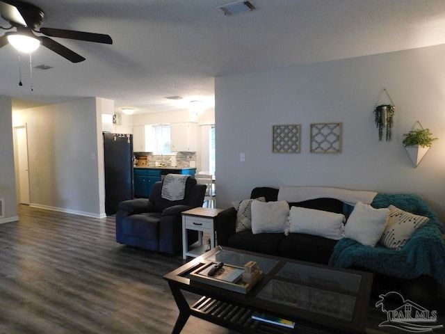 living room featuring hardwood / wood-style floors, a textured ceiling, and ceiling fan