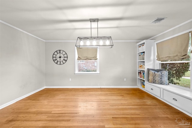 unfurnished dining area with a wealth of natural light, crown molding, and light hardwood / wood-style flooring