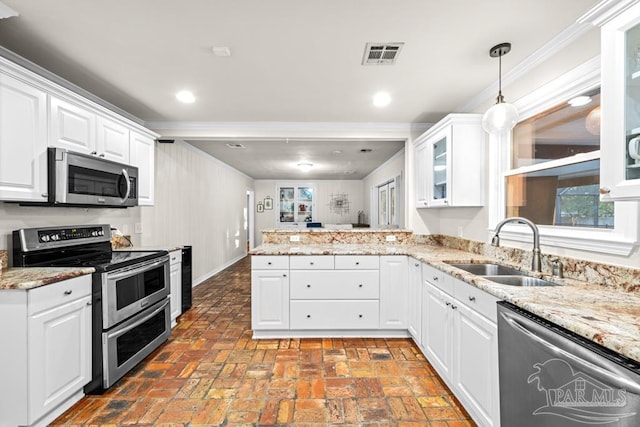 kitchen with kitchen peninsula, hanging light fixtures, sink, white cabinetry, and appliances with stainless steel finishes