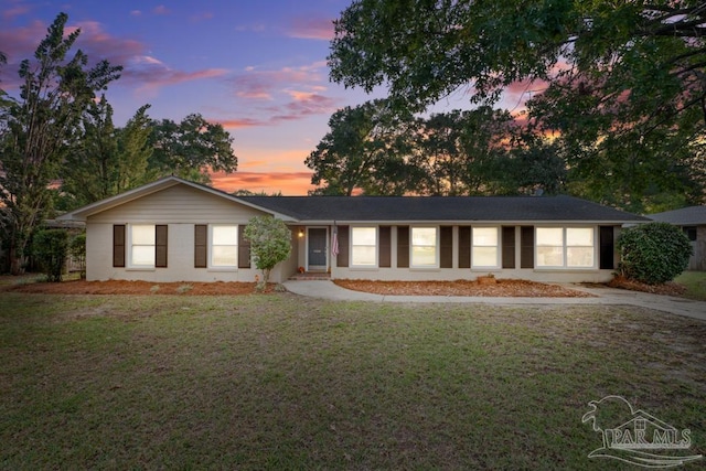 single story home featuring a lawn