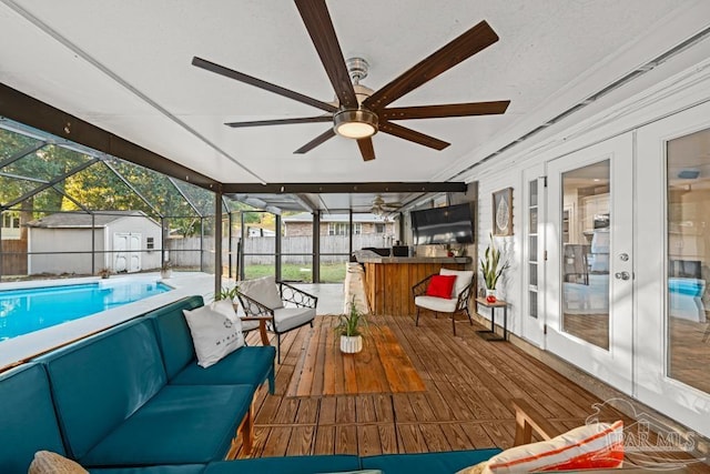 unfurnished sunroom featuring ceiling fan and a pool