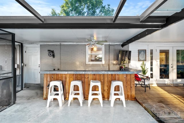 exterior space featuring ceiling fan, beam ceiling, and concrete floors