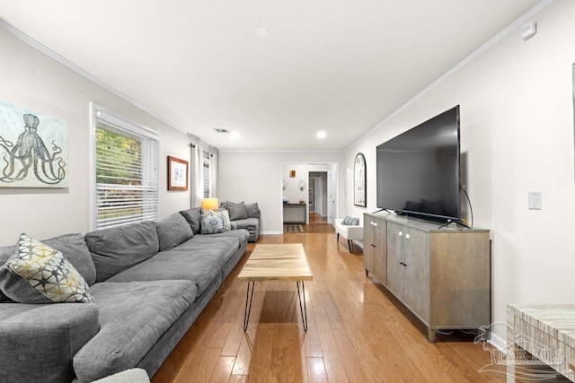 living room featuring light hardwood / wood-style flooring and crown molding