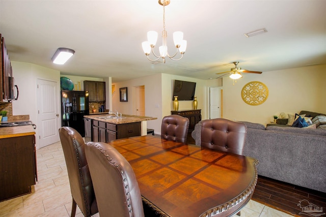 dining area with sink and ceiling fan with notable chandelier