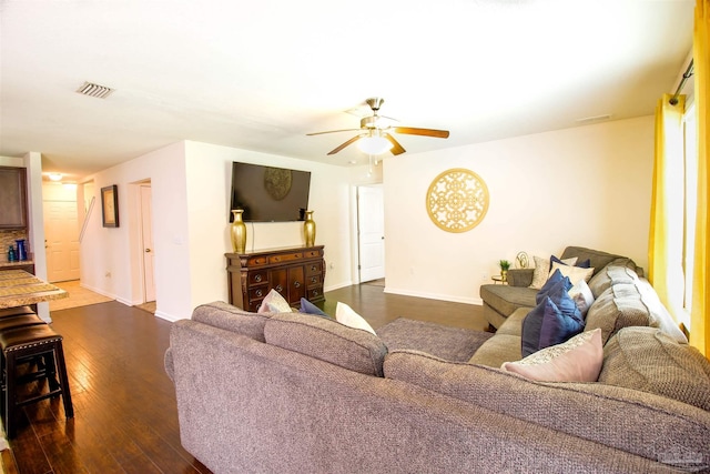 living room featuring ceiling fan and dark hardwood / wood-style flooring