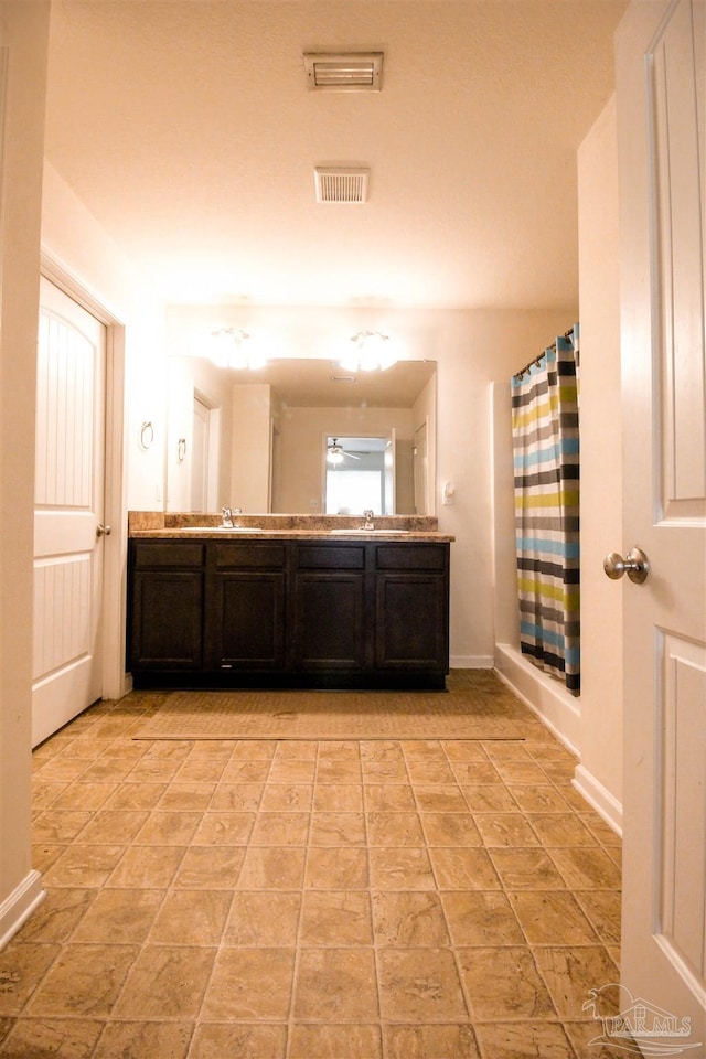 bathroom featuring vanity, ceiling fan, and walk in shower