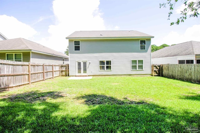 rear view of property with a lawn