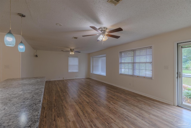 unfurnished room with ceiling fan, wood-type flooring, and a textured ceiling