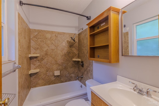 full bathroom featuring vanity, a textured ceiling, toilet, and tiled shower / bath