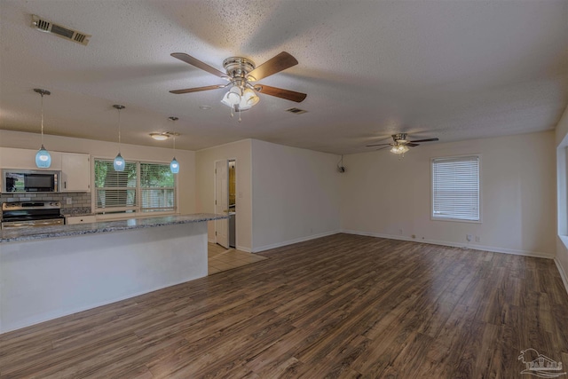 unfurnished living room with ceiling fan, wood-type flooring, and a textured ceiling