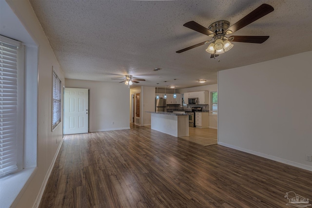 unfurnished living room featuring ceiling fan, a textured ceiling, and hardwood / wood-style flooring