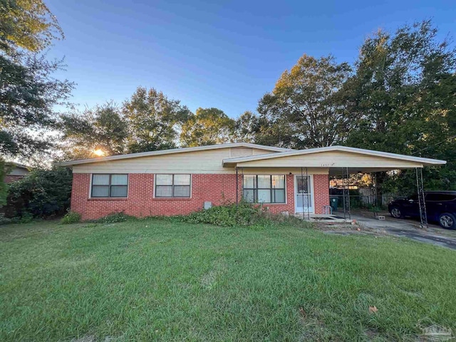 single story home featuring a front lawn and a carport