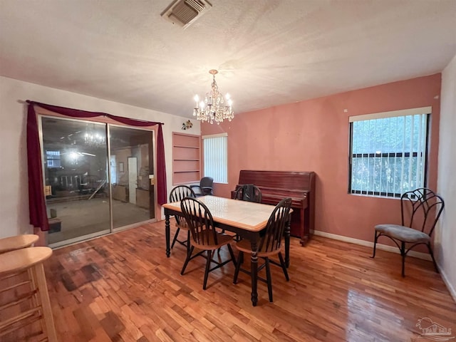 5457 Byrom St, Milton, FL 32570 - dining space with wood finished floors and a chandelier