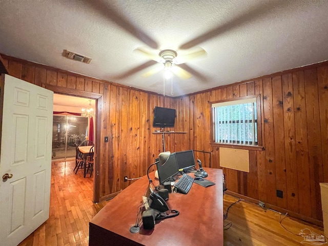 5457 Byrom St, Milton, FL 32570 - home office featuring light wood-style floors, ceiling fan, wood walls, and a textured ceiling