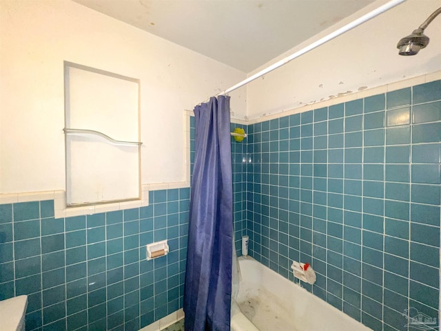 5457 Byrom St, Milton, FL 32570 - bathroom featuring tile walls, shower / tub combo with curtain, and a wainscoted wall