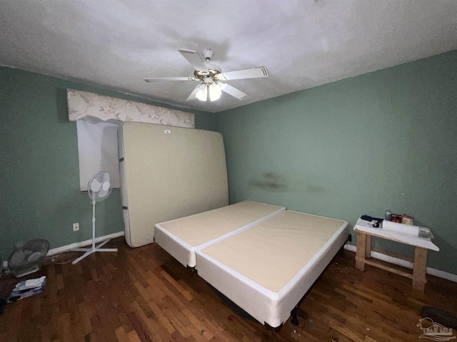 bedroom with a textured ceiling, ceiling fan, and dark wood-type flooring