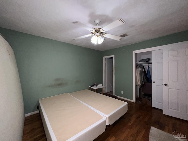 bedroom with a closet, dark wood-type flooring, and ceiling fan