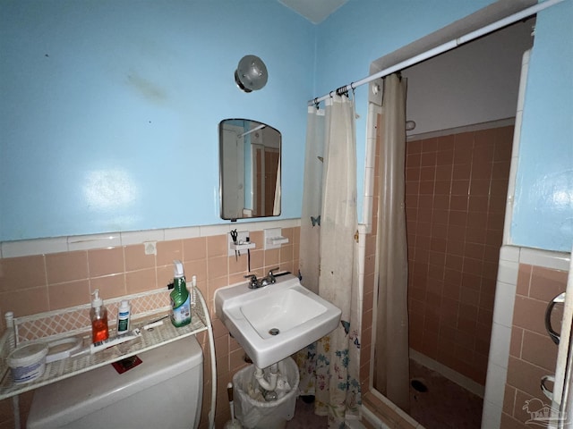 bathroom with curtained shower, tile walls, and toilet