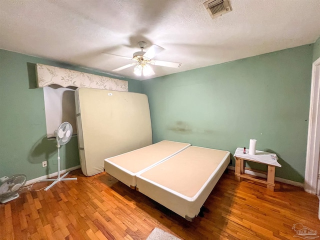 5457 Byrom St, Milton, FL 32570 - bedroom with wood finished floors, ceiling fan, and a textured ceiling
