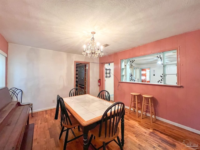 5457 Byrom St, Milton, FL 32570 - dining room with wood finished floors, a chandelier, and a textured ceiling