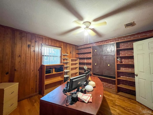 5457 Byrom St, Milton, FL 32570 - office space with wood finished floors, ceiling fan, wood walls, a textured ceiling, and brick wall
