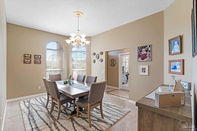 dining area with light carpet, a textured ceiling, and a notable chandelier