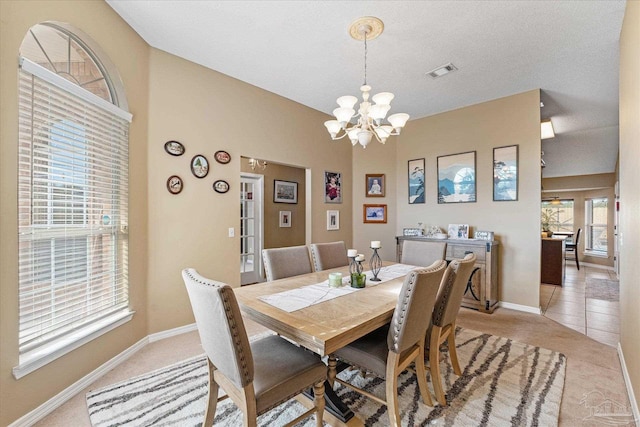 tiled dining space featuring a notable chandelier