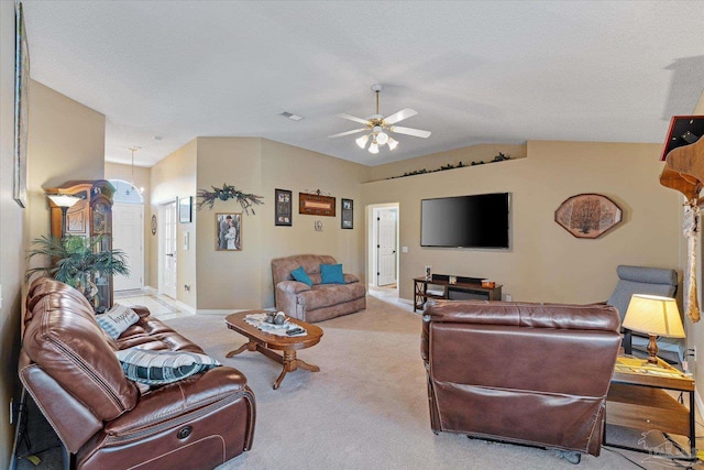 carpeted living room with ceiling fan and vaulted ceiling