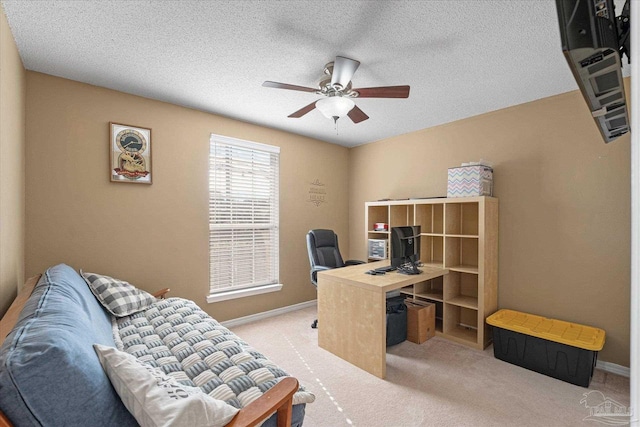 home office featuring ceiling fan, light colored carpet, and a textured ceiling