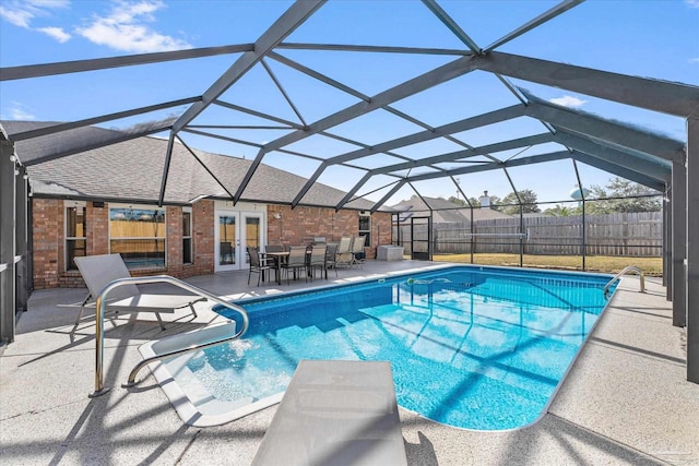 view of pool with a lanai, a patio area, and french doors