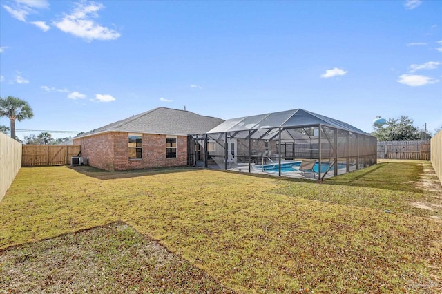 view of yard with a lanai, central AC, a patio, and a fenced in pool