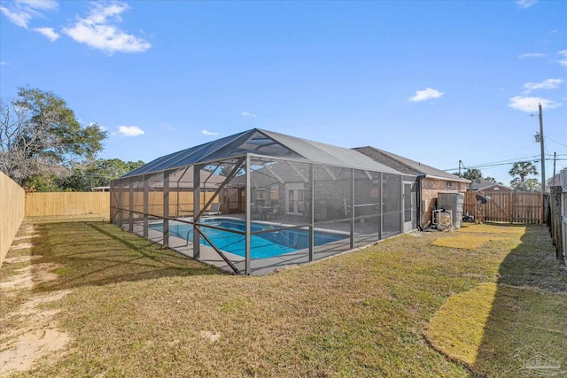 view of swimming pool with a yard and a lanai