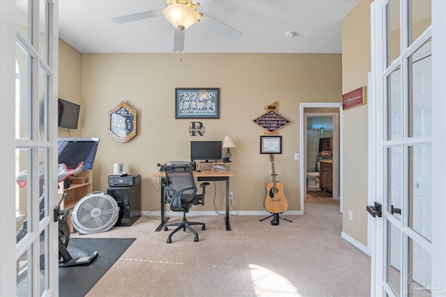 carpeted office space with ceiling fan and french doors