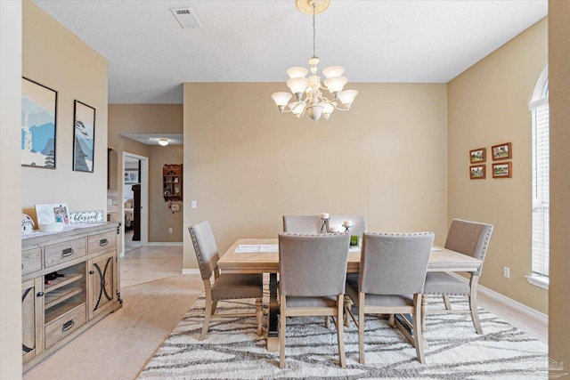 carpeted dining area with a textured ceiling, an inviting chandelier, and a wealth of natural light