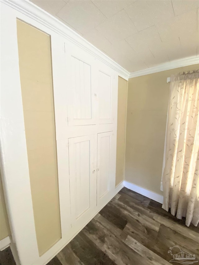 unfurnished bedroom featuring crown molding and dark hardwood / wood-style floors